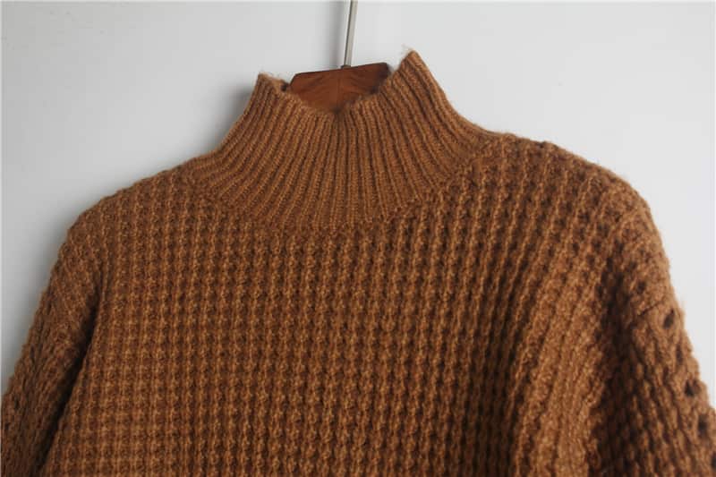 Close-up of a waffle-knit sweater made by Belleza, showing stitch definition at the collar